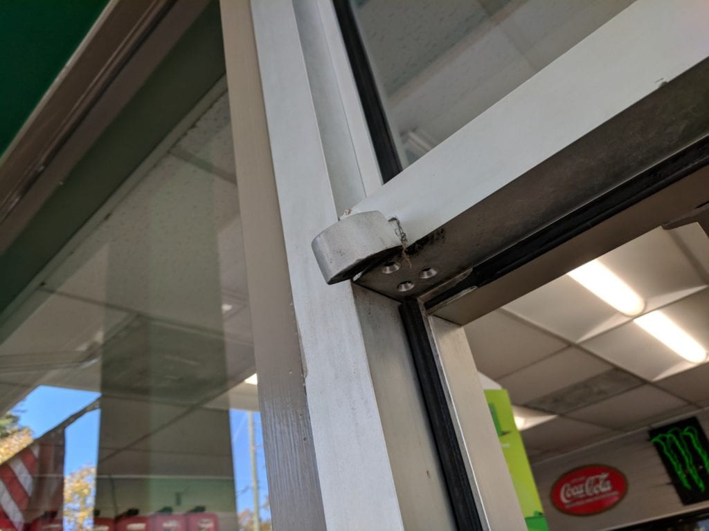 Broken top pivot hinge on aluminum storefront door 