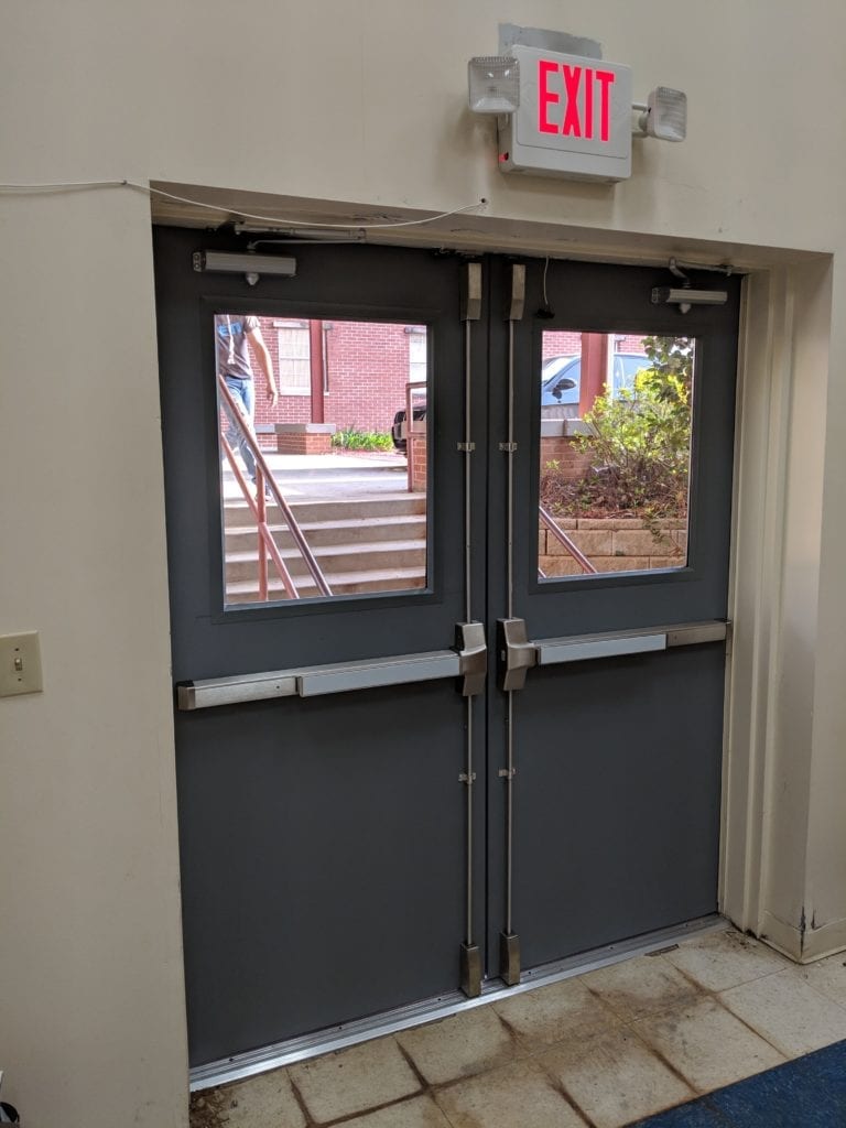 two stainless vertical rod panic devices installed on a pair of hollow metal door that we added windows to.